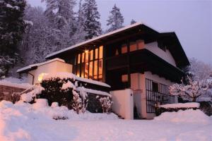 ein schneebedecktes Haus mit eingeschaltetem Licht in der Unterkunft Haus Christine in Mieders