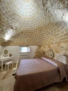 a bedroom with a large bed in a brick wall at Trulli San Pietro in Putignano