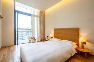 Voodi või voodid majutusasutuse Taihua Wutong Hotel toas