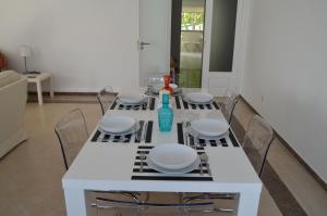 a white table with chairs and a vase on it at Alegre Apartamento in Cascais