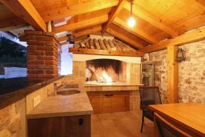 a kitchen with a fireplace and a sink at Villa Bonavita in Sukošan