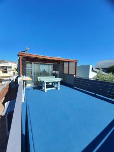 a picnic table on the roof of a building at KUSVAALBOS SELFSORG WOONSTEL in De Kelders