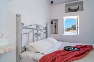 a bedroom with a bed with a red blanket on it at Peaceful Lindos in Lindos