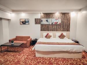 ein Hotelzimmer mit einem großen Bett und einem Stuhl in der Unterkunft The Altruist Hotel Kharadi in Pune + 67 Fotos