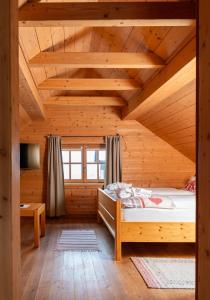 Uma cama ou camas num quarto em Almhüttendorf Klippitztörl