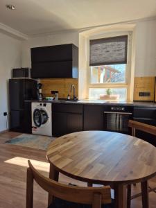 a kitchen with a wooden table and a kitchen with a stove at Apartment #1 in Olsbrücken