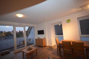ein Wohnzimmer mit einem Esstisch und einem Balkon in der Unterkunft Ferienwohnung Hagener Meer in Mehrhoog