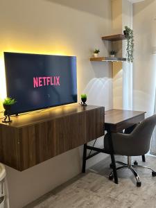 TV in/ali zabaviščno središče v nastanitvi Minglanilla Condo with Pool, Gym & Fast WiFi