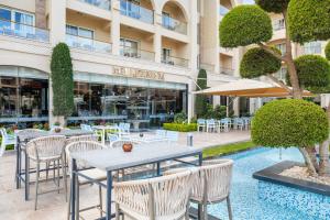 a restaurant with tables and chairs in front of a building at Pickalbatros White Beach Resort - Hurghada in Hurghada