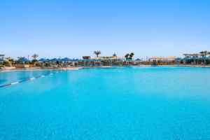 a large pool of blue water with tables and umbrellas at Pickalbatros White Beach Resort - Hurghada in Hurghada