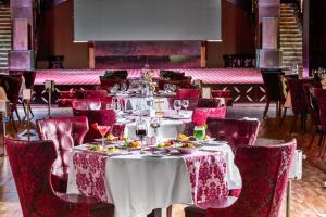 a dining room with white tables and red chairs at Pickalbatros White Beach Resort - Hurghada in Hurghada