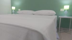 a white bed with two pillows on top of it at La Sanfelice in Agropoli +18 photos