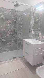a white bathroom with a shower and a sink at La Sanfelice in Agropoli