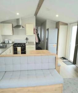 a living room with a white couch in a kitchen at 6 berth golden sands Rhyl in Kinmel Bay +2 photos