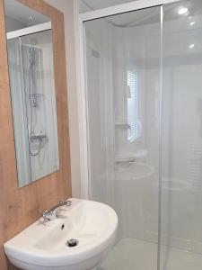a bathroom with a white sink and a shower at 6 berth golden sands Rhyl in Kinmel Bay
