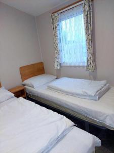 two beds in a small room with a window at 6 berth golden sands Rhyl in Kinmel Bay