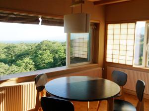 a dining room with a table and chairs and windows at Wakaki Ryokan - Nasu Yumoto Onsen in Nasu