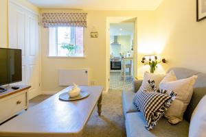 a living room with a couch and a tv at Acorn Cottage in Quorndon