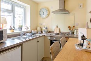 a kitchen with a sink and a clock on the wall at Acorn Cottage in Quorndon +37 photos