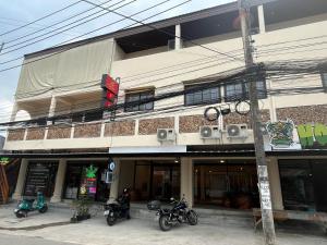 苏梅岛Tian Ming Hostel的一栋建筑前停放着摩托车
