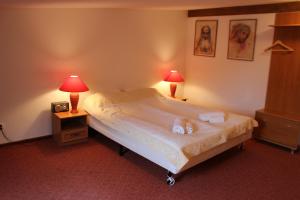 een slaapkamer met een bed met 2 lampen en een wekker bij Apartament Stara Kamienica in Kętrzyn