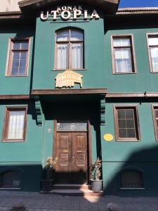 a blue building with a wooden door in front of it at Utopia Konak Otel in Bozuyuk