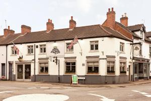 a large white building on the corner of a street at Acorn Cottage in Quorndon