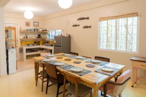 a dining room with a table and chairs in a kitchen at Baroro Beach House LU in Bacnotan