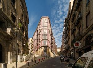 a tall building on a city street with buildings at Monappart Cristo Historic Apartment with Parking in Bilbao