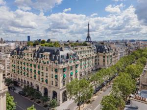 un ancien bâtiment de paris avec la tour eiffel dans l'établissement The Peninsula Paris, à Paris