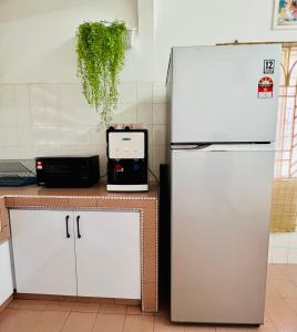 a kitchen with a refrigerator and a microwave on a counter at The Pine Lodge- Bukit Tinggi Klang in Klang
