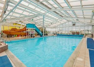 a large indoor swimming pool with a water slide at Accessible and dog friendly caravan in Ingoldmells
