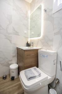 a bathroom with a toilet and a sink and a mirror at Nioplias Luxury Apartments Pefkohori in Pefkohori