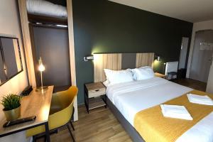 una camera d'albergo con letto, scrivania e letto di Hôtel Lodge In Paris 13 a Parigi