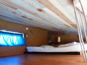 a bedroom with a hanging bed with a blue window at Studio de pleine nature idéal pour se ressourcer en solo in Chenaillers-Mascheix