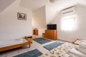a living room with a bed and a tv at Szeparé pinceház szállás Villány in Villány