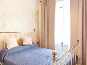 a bedroom with a bed with blue sheets and a window at Rifugio Al Mare in Genova