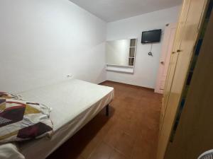 a bedroom with a bed and a tv on the wall at Wbs in Almería