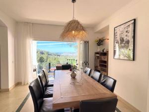 une salle à manger avec une table en bois et des fauteuils en cuir dans l'établissement Villa Sunset Bay, à San José
