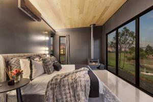 a bedroom with a bed and a large window at McGill Vineyard Moffatdale in Moffatdale +13 photos