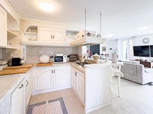 a kitchen with white cabinets and a couch at Villa Rosa in Camogli