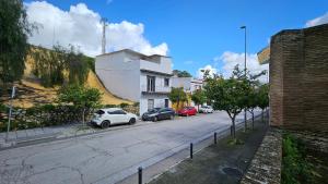 una calle con coches aparcados al costado de la carretera en Optimus Caura, en Coria del Río