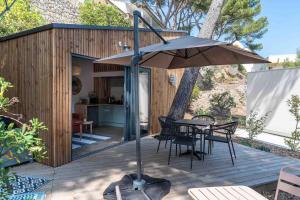 un patio con ombrellone, tavolo e sedie di La cabane a Narbonne-Plage