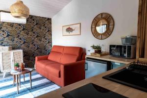 un soggiorno con sedia rossa e una cucina di La cabane a Narbonne-Plage Altre 21 foto