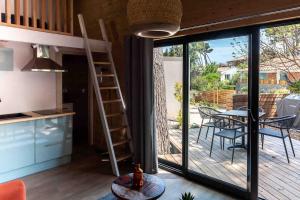 una cucina e una sala da pranzo con balcone e tavolo di La cabane a Narbonne-Plage