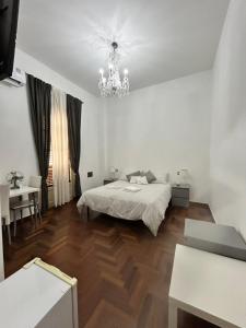 een witte slaapkamer met een bed en een kroonluchter bij B&B Paolo e Mariella in Palermo