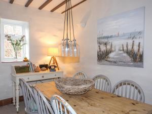ein Esszimmer mit einem Holztisch und Stühlen in der Unterkunft Riverwash Cottage in Penmaen-mawr