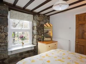 ein Schlafzimmer mit einem Bett und einem Fenster in der Unterkunft Riverwash Cottage in Penmaen-mawr