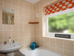 ein Badezimmer mit Waschbecken und Toilette und einem Fenster in der Unterkunft Riverwash Cottage in Penmaen-mawr + 43 Fotos