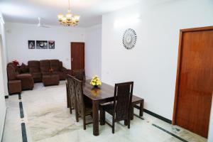 a dining room with a table and chairs and a couch at Rich inn Palace Tnagar in Chennai +34 photos